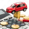 An Image of a toy car on astack of coins next to a calculator